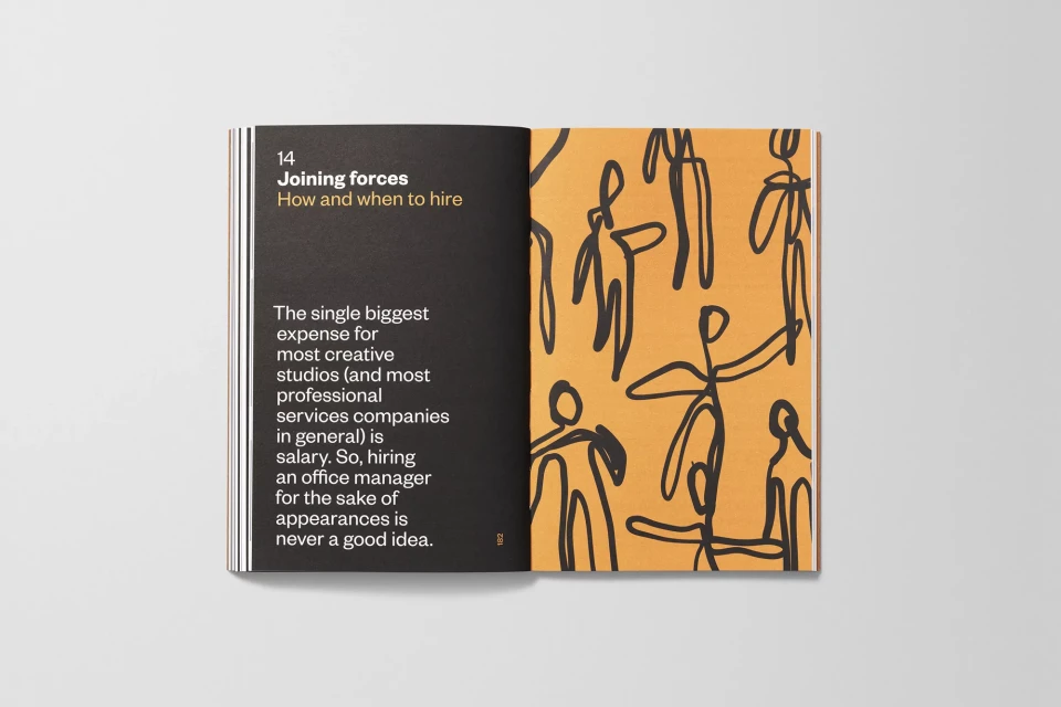 Open book lies flat, featuring abstract figures on orange page with text on black. Academic or business publication concept.
