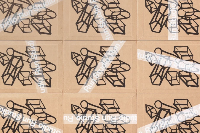 Nine tan squares display bold, black, line-art abstract shapes and the words 'Studio Run Studio' in a repeating, transparent overlay.