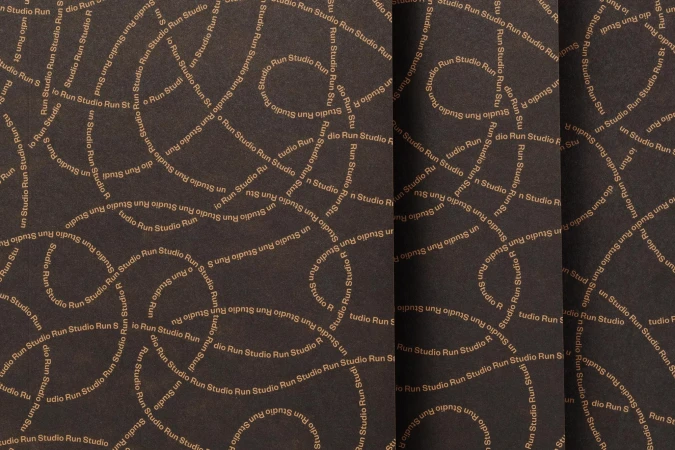 Abstract background with swirling tan text of 'Studio Run' on a dark brown textured surface, creating a dynamic and patterned visual.