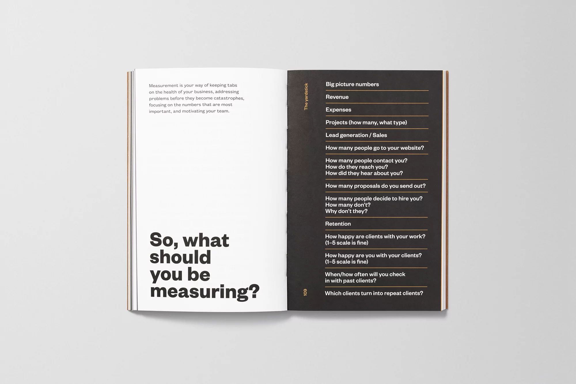 Open book on a white surface showing a list of questions and business metrics on one page and a question on the other.