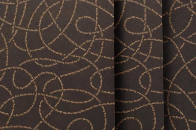 Dark textured paper featuring a repeating typographic pattern of curved phrases reading Studio Run in gold ink.