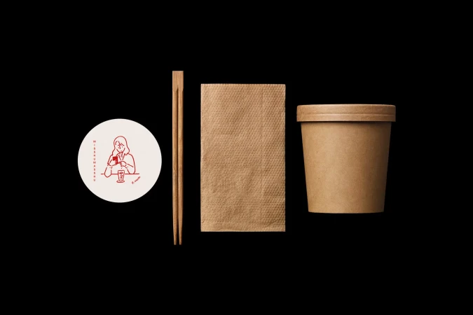 Still life of a paper cup with a lid, chopsticks, a paper napkin, and a coaster with a red outline drawing on a black background.