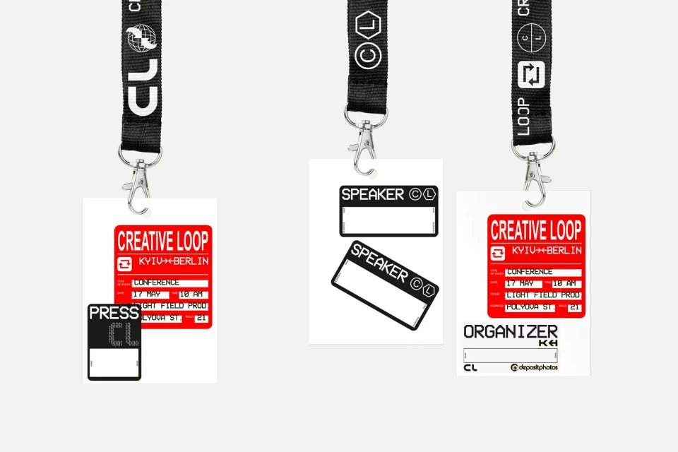 Three event passes hanging from lanyards on a white background display conference and speaker information with event branding.