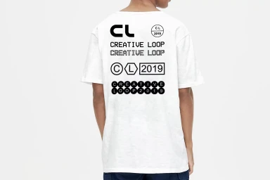 Person wearing a white t-shirt with black typographic branding on the back against a white seamless background
