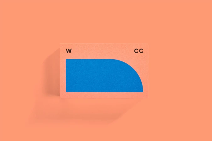 Textured peach background with centered business card featuring blue geometric design and 'W' and 'CC' typography.