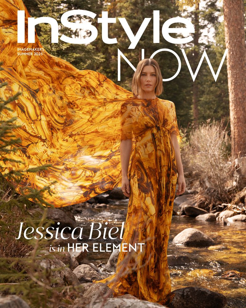 Jessica Biel on the cover of InStyle magazine, wearing a yellow dress, posing in nature by a stream, with a forest background.