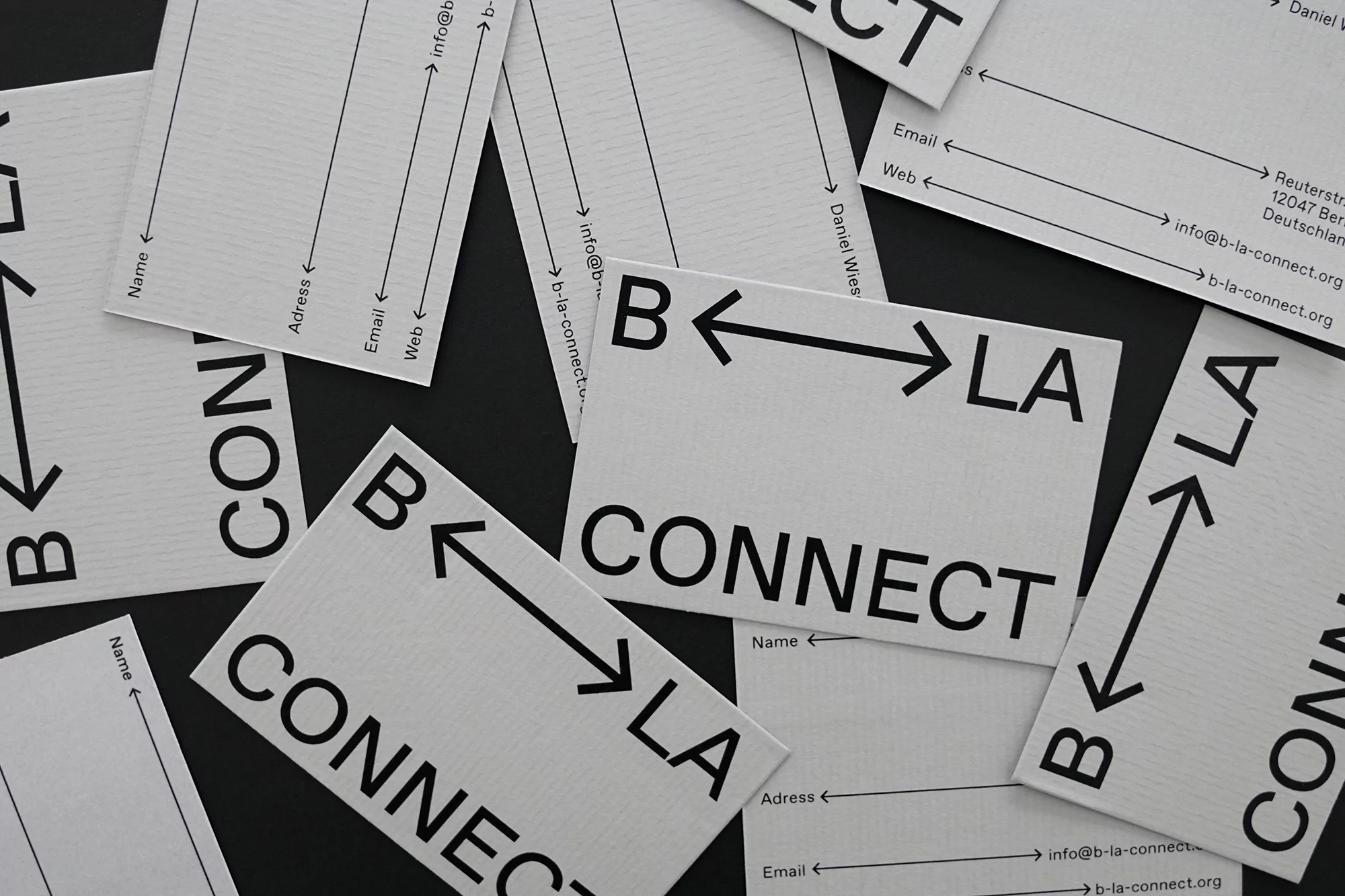 Scattered business cards on a black surface display company name and contact information with bold black arrows and text for 'Connect'.