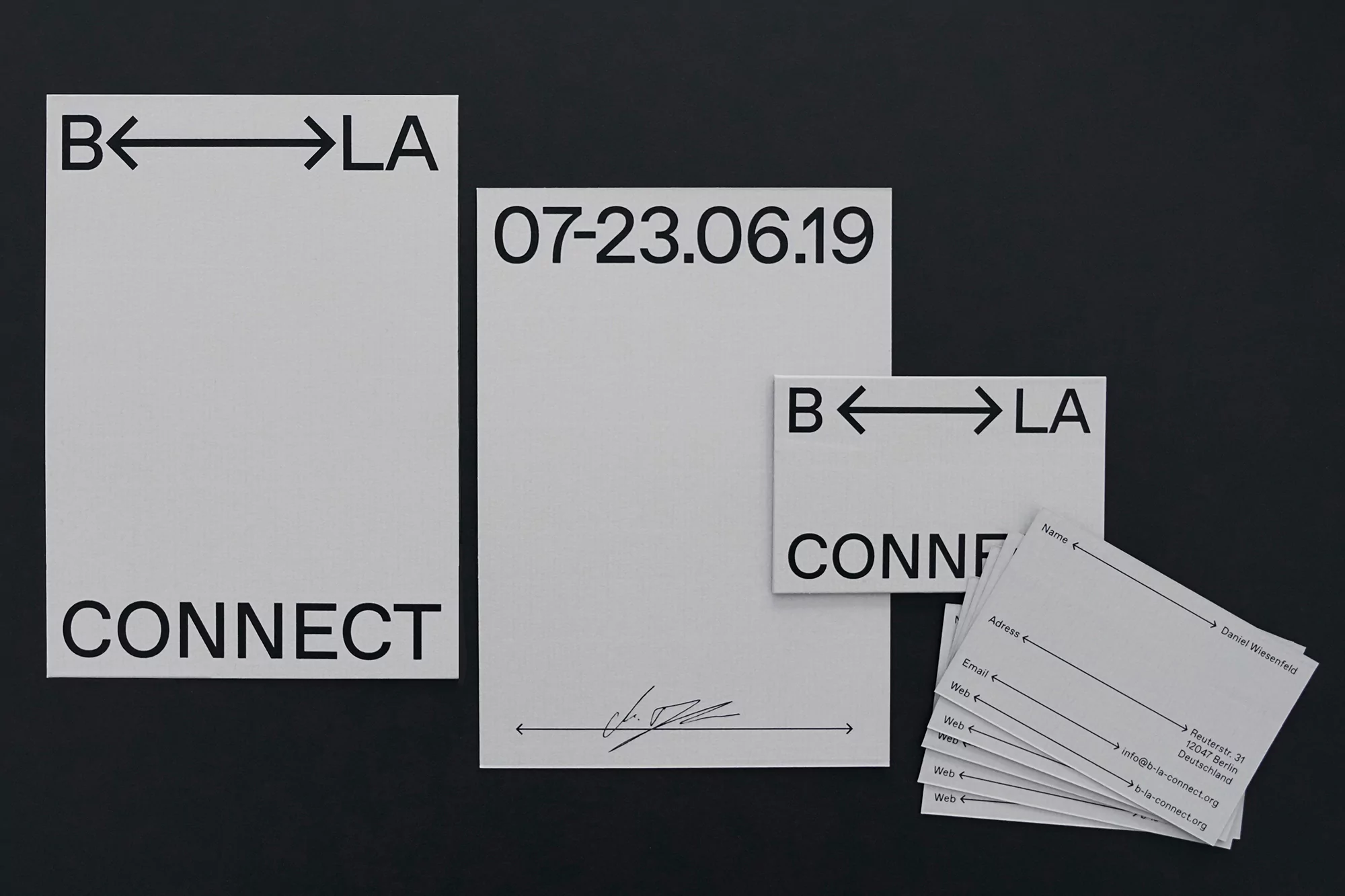 Stationery set features a logo design with arrows and typography, including letterhead, business cards, and paper against a black background.