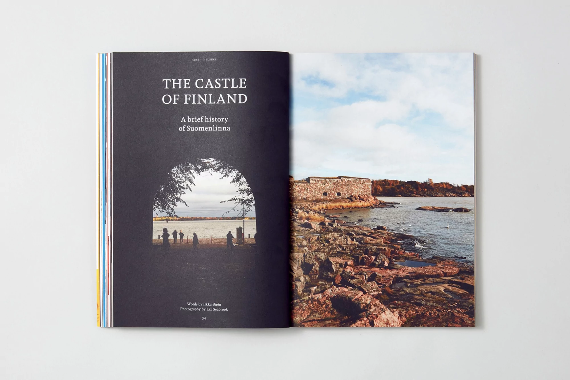 Magazine spread featuring Finland's castle history, showcasing an arched view of a beach and a rocky coast with a fortress.