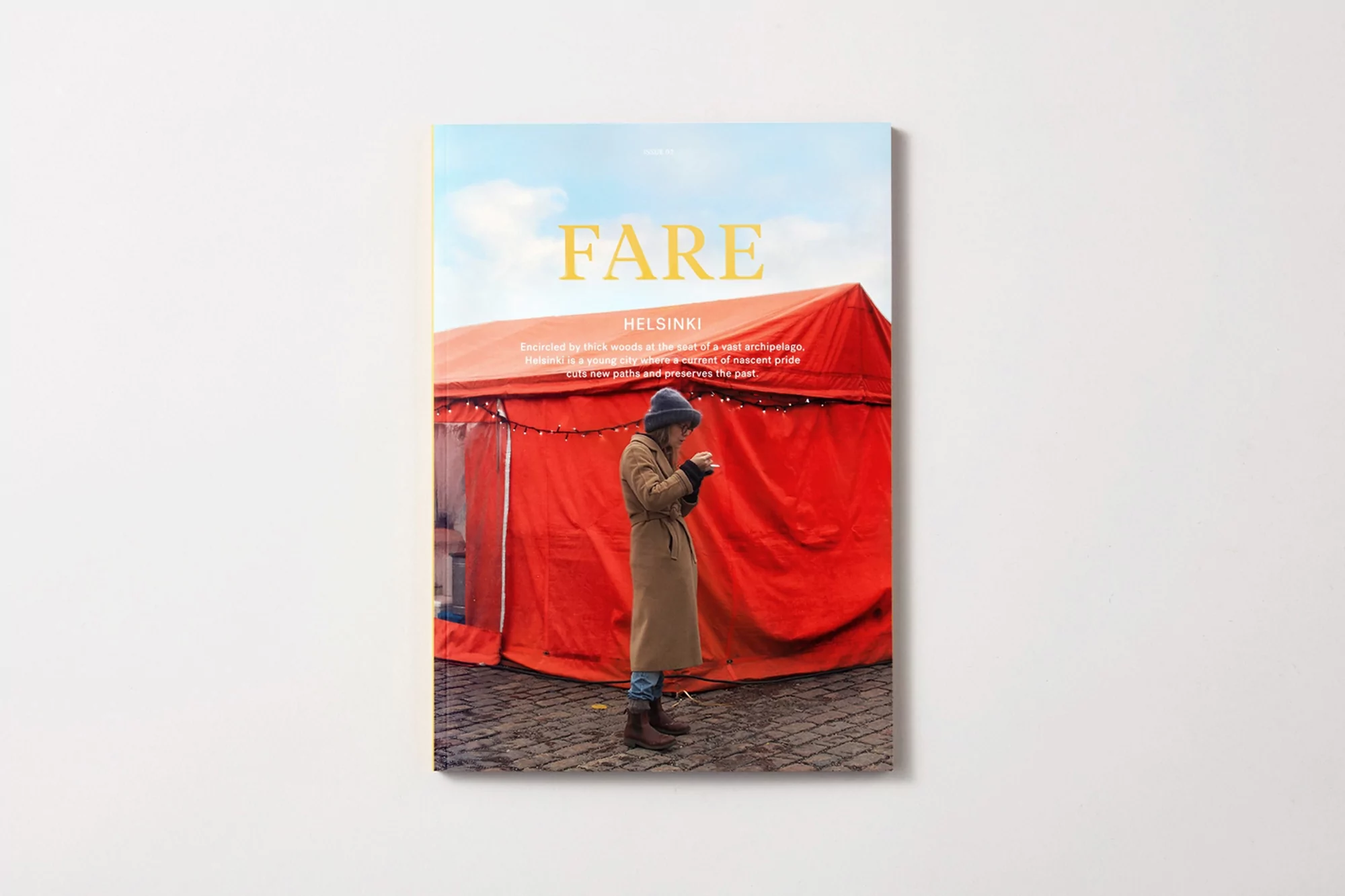 Fare Helsinki magazine cover featuring a person standing in front of a red tent under a blue sky with clouds on a white background.