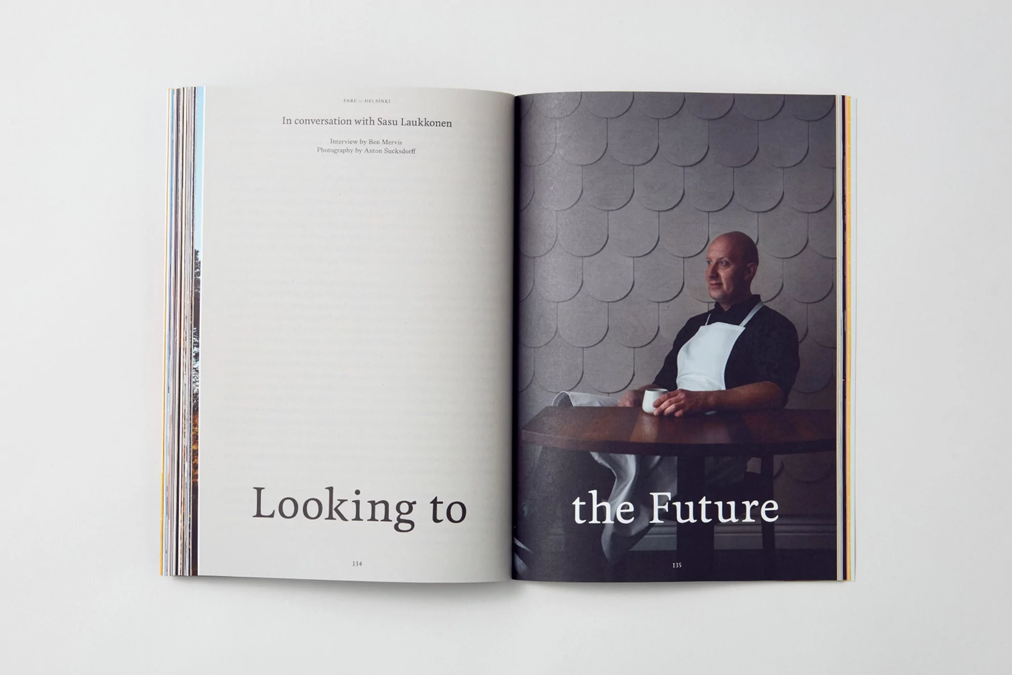 Magazine spread features a portrait of an adult male chef at a table, contrasted by text on the opposing page.