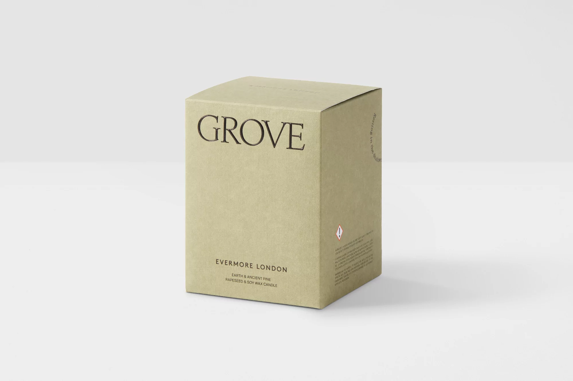 Beige candle in a box by Evermore London featuring 'Grove' scent with notes of earth, ancient pine, rapeseed, and soy wax candles.
