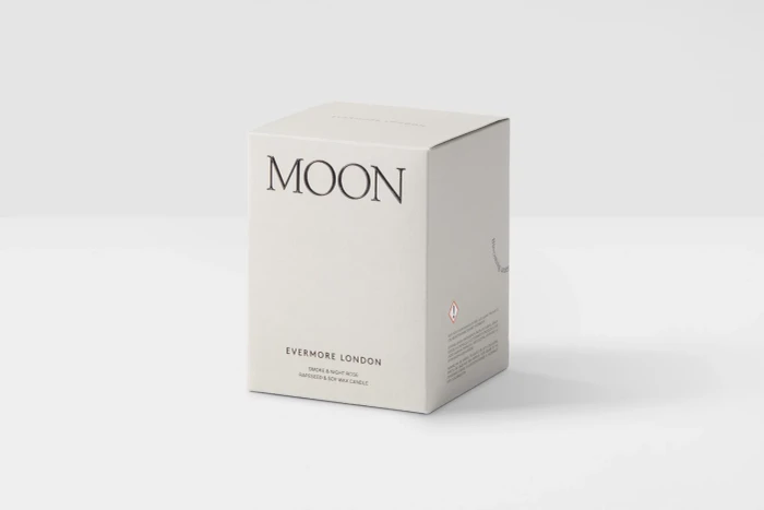 Off-white square product packaging box with black serif typography spelling Moon and Evermore London on a seamless white studio background