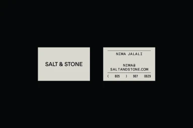 Minimalist business cards featuring the Salt and Stone brand identity on a solid black background.