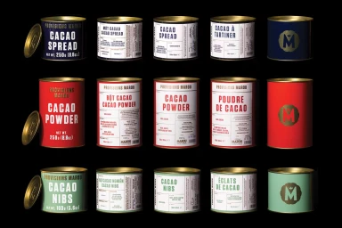 Fifteen cylindrical tins of Marou cacao products arranged in a grid against a black background with gold lids and typography.