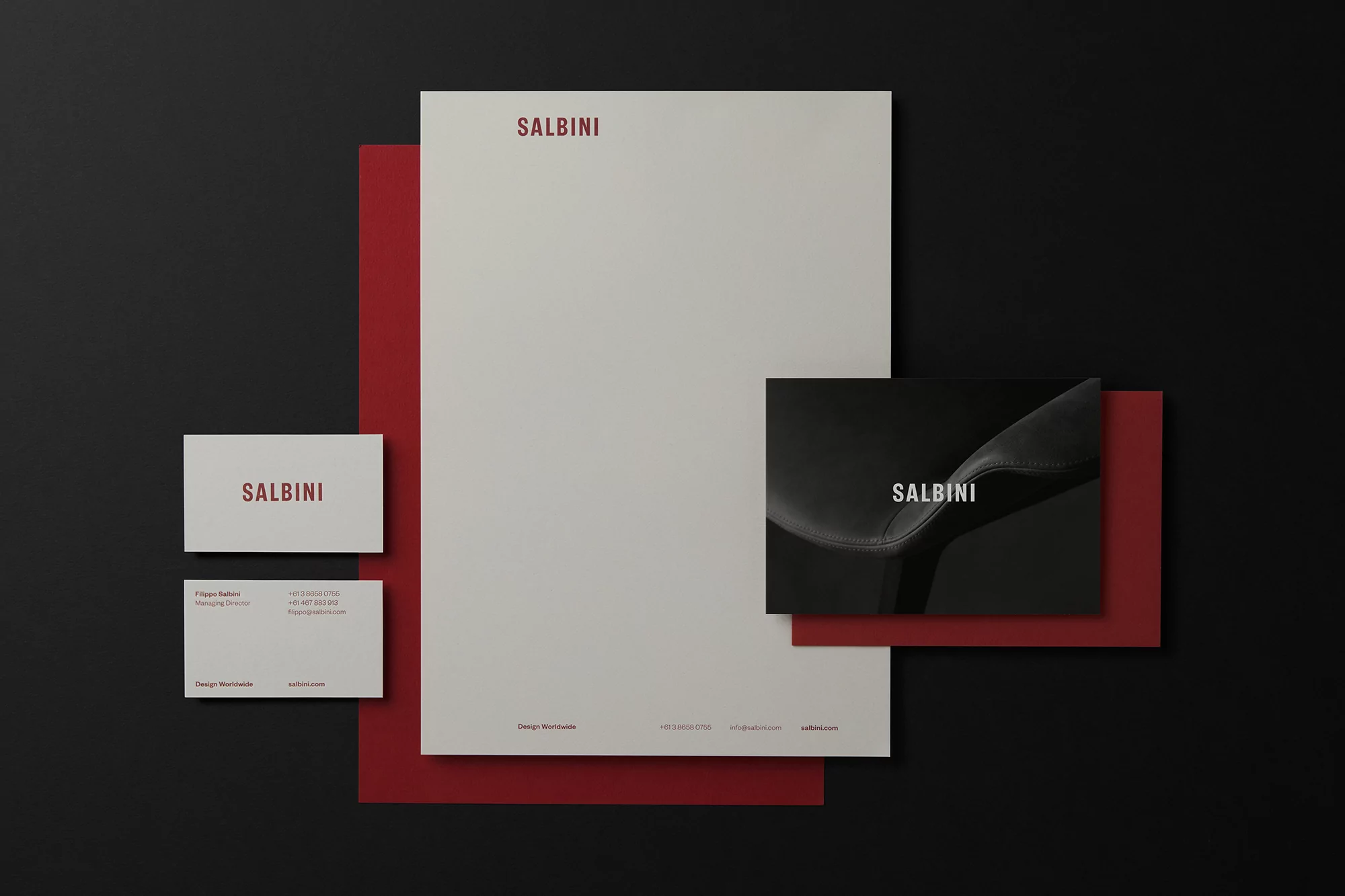 Letterhead, business cards, and square card mockup with the brand name 'Salbini' in red, arranged on a black background with a red card.