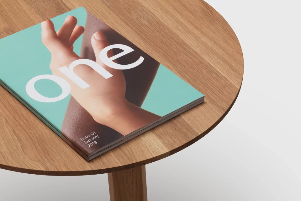 Magazine cover featuring a hand on a round wood table. The magazine's title is 'one' and reads 'Issue 01, January 2019'.