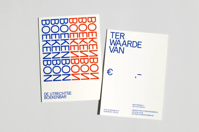 Two gift cards with book-related text in red and blue on white background, displayed in a studio setup.