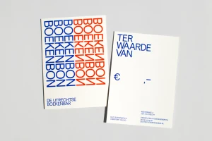 Two printed paper cards featuring blue and red repeating typography on a grey background