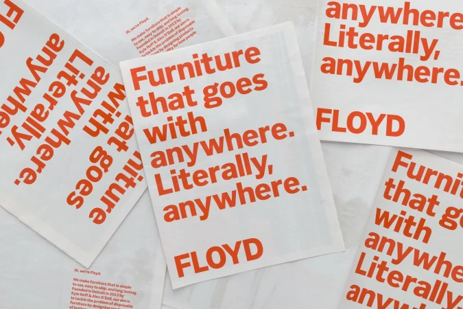 Promotional material featuring the word 'Furniture that goes with anywhere. Literally, anywhere. FLOYD' printed in coral color on white.