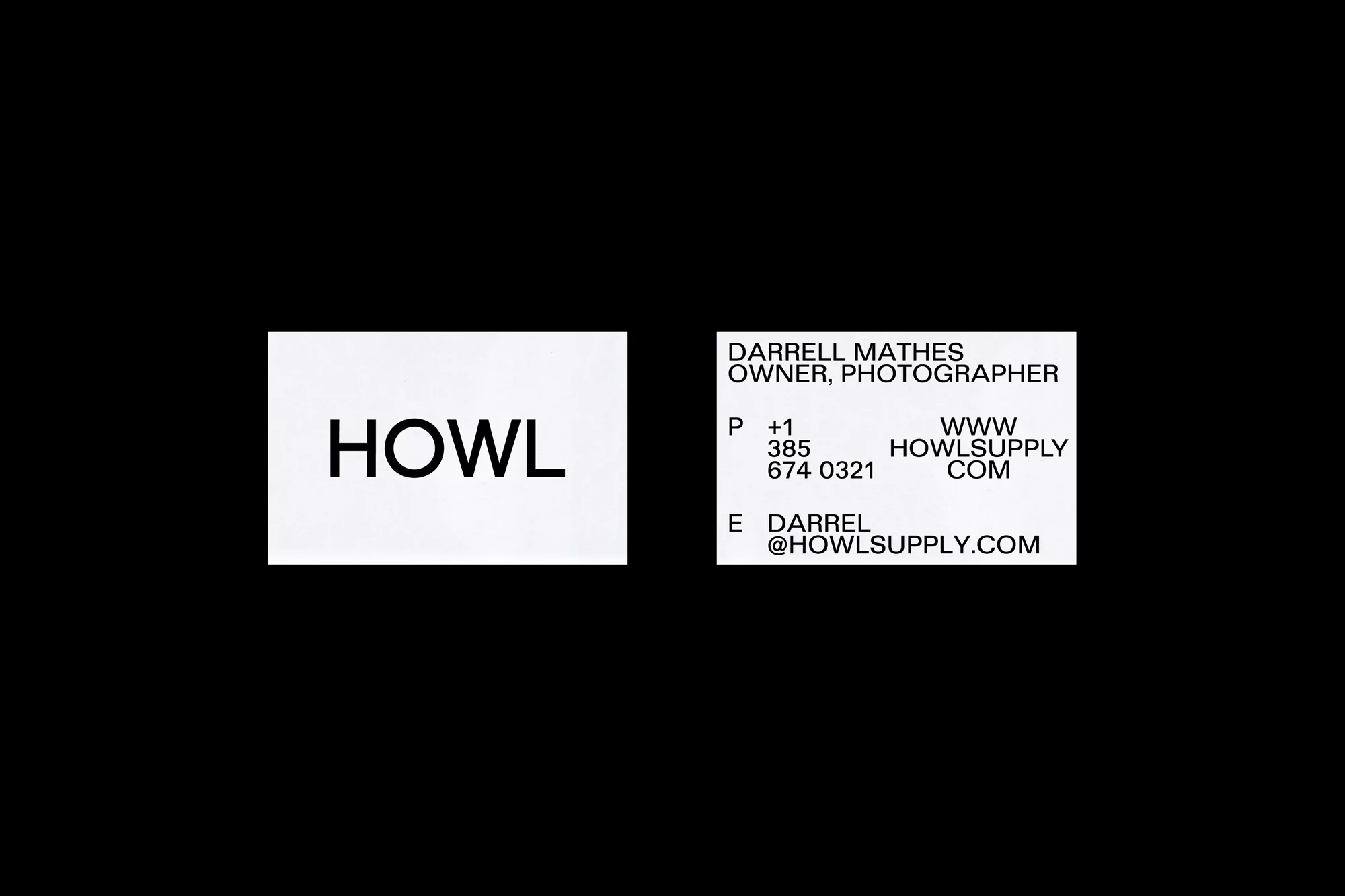 Two white business cards with black typography displayed against a solid dark background