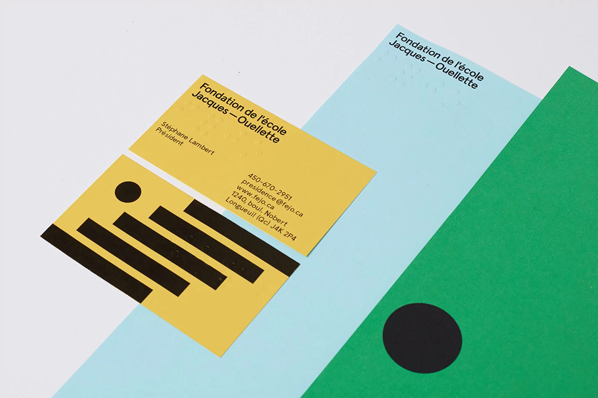 Promotional image featuring business cards for Fondation de l'école Jacques-Ouellette on colorful geometric paper, minimalist design.