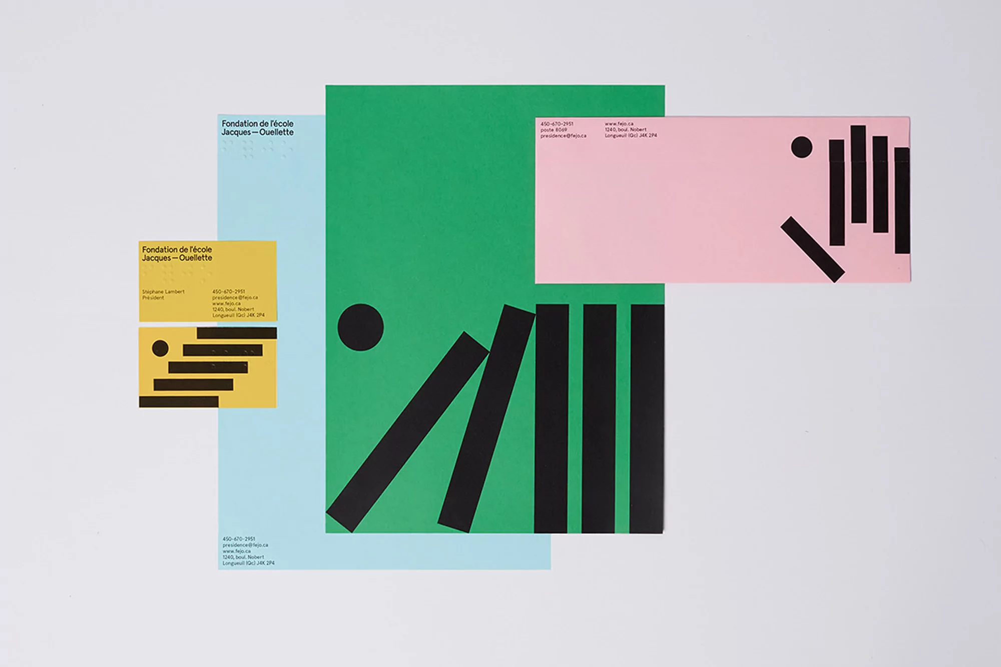 Colorful geometric designs on stationery, including black bars and circles on pink, green, yellow, and blue paper against a white background.