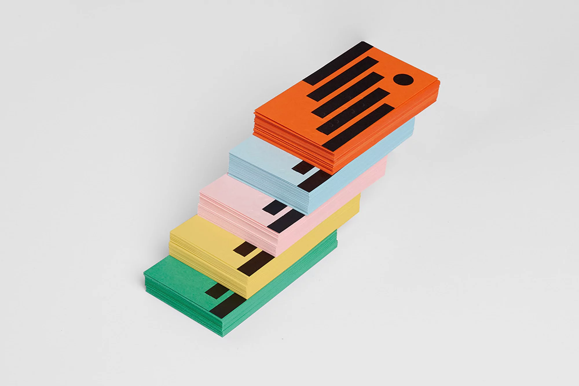 Stack of colorful business cards with a modern geometric design on a white background, promoting a visual and creative aesthetic.