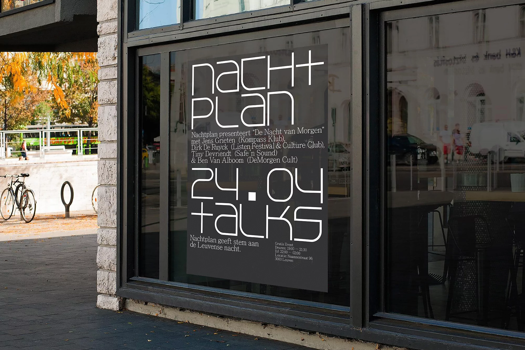 Outdoor view of a poster on a window advertising an event called Nachtplan, featuring white text on a black background.