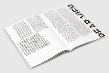 Open publication layout featuring columns of French text and bold typography on white pages resting on a surface