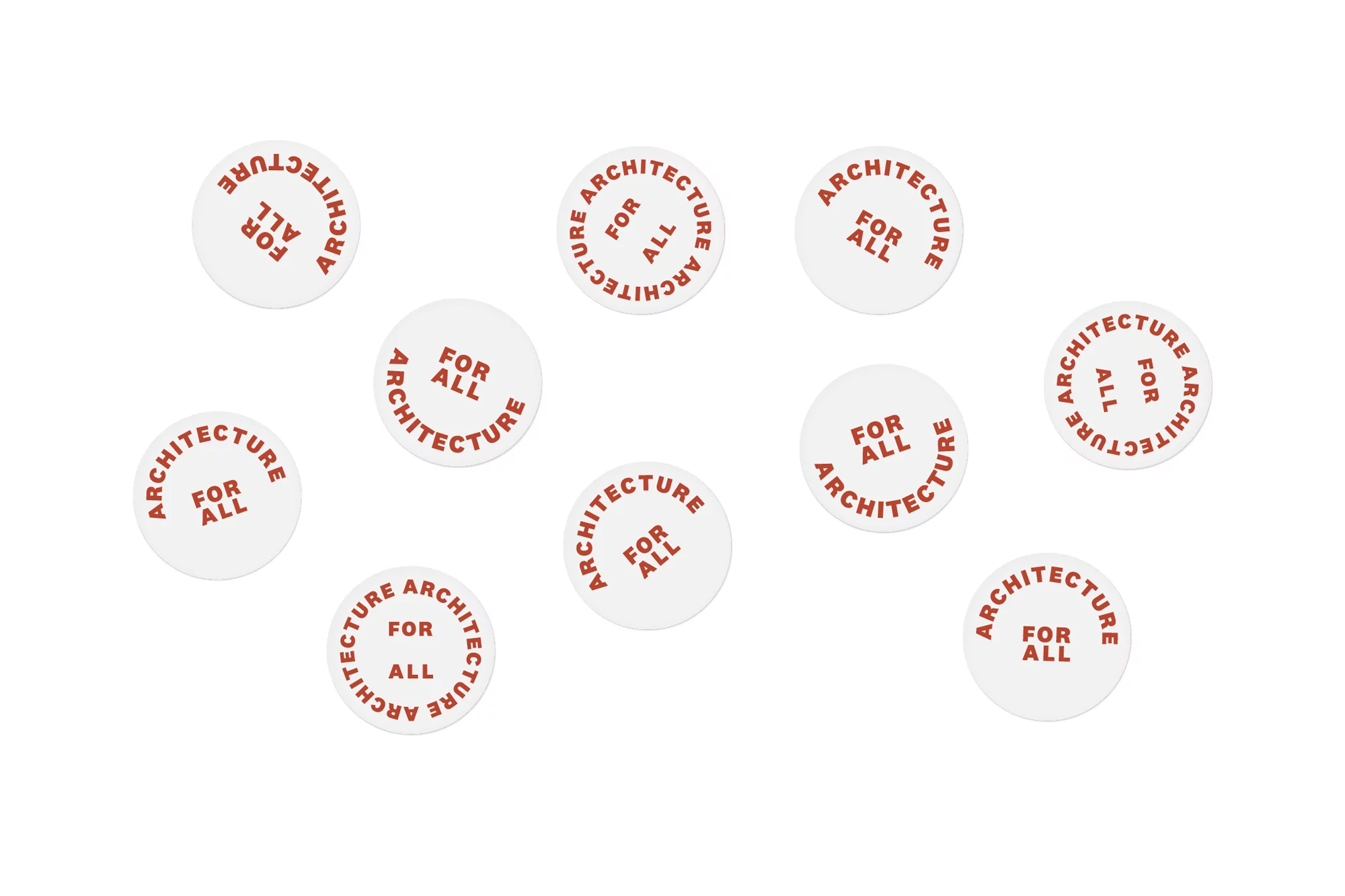 Eleven white circular stickers or labels are arranged on a white surface, each printed with 'ARCHITECTURE FOR ALL' in brown text.