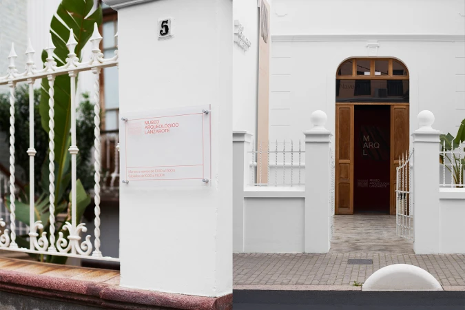 Facade of Museo Arqueologico Lanzarote, featuring white walls, brown doors, and a clear sign with red text in the Canary Islands.
