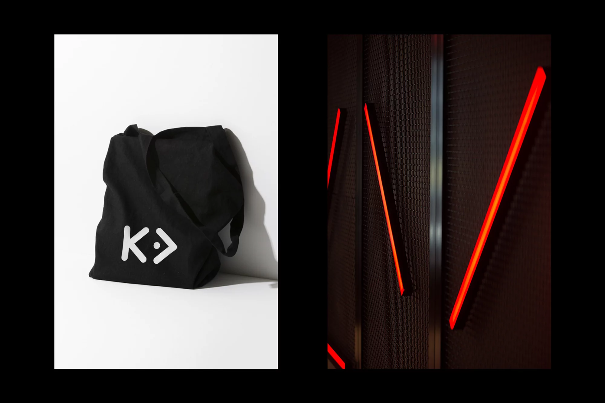 Studio shot of a black tote bag with a white logo, positioned against a white wall, alongside a dark wall with illuminated red lines.