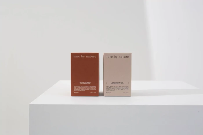 Two product packaging boxes for Rare by Nature positioned side by side on a minimalist white display surface.