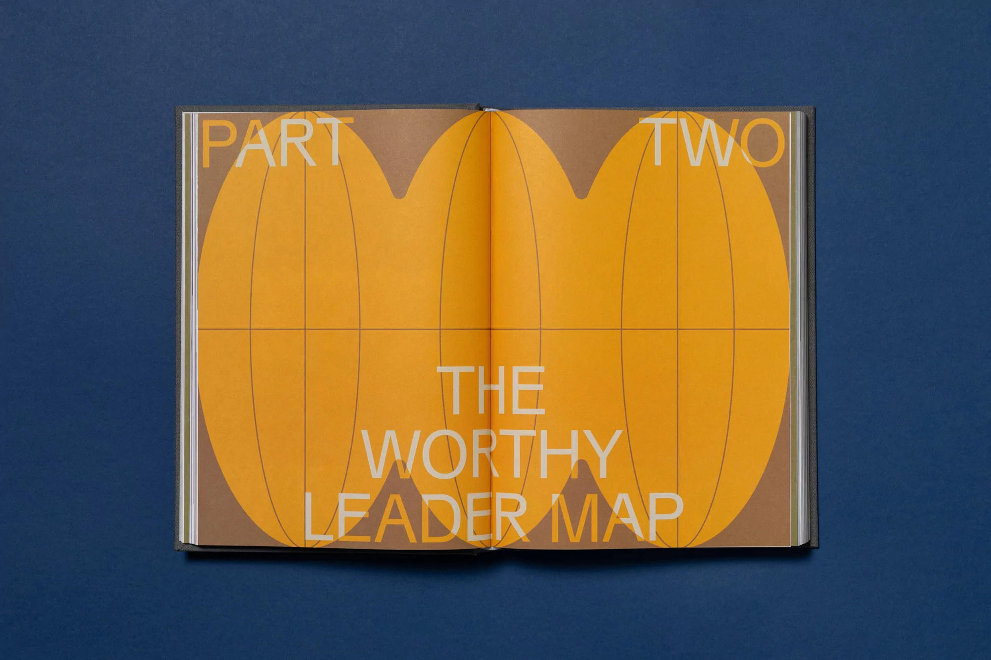 Opened book displaying graphic design of two halves of a globe in shades of brown and orange with the text 'Part Two' and 'The Worthy Leader Map'.