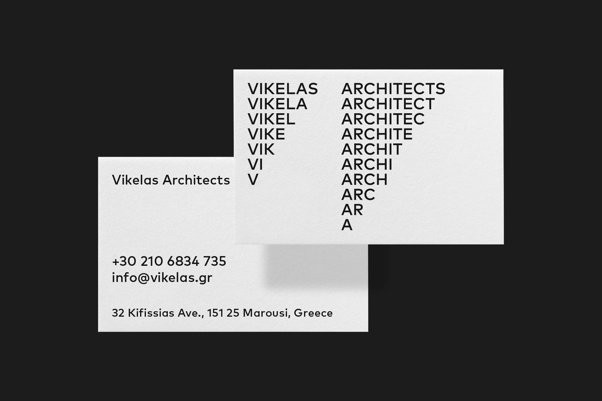 Two business cards for Vikelas Architects. One shows contact information, the other the company name rendered in a deconstructed format.