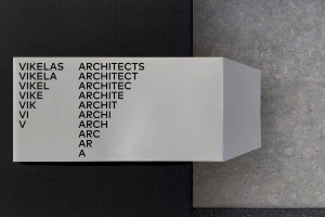 White folded dimensional logo signage for Vikelas Architects with progressive letter removal typography