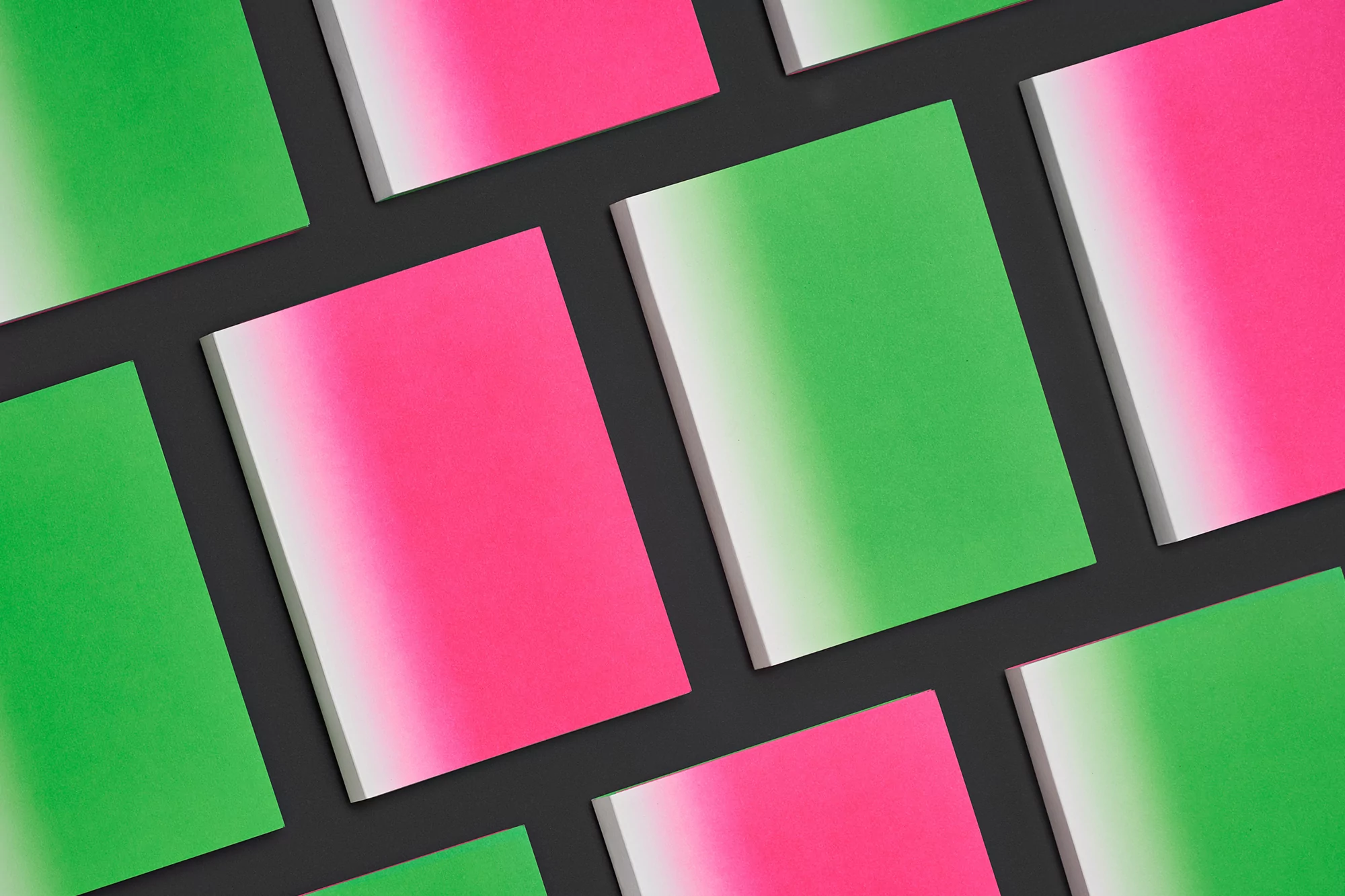 Graphic arrangement of green and pink notebooks with a color gradient against a dark grey background, suitable for graphic design use.
