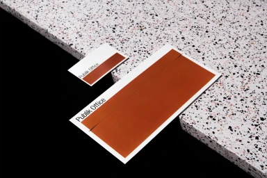 Publik Office brand identity stationery featuring rust-coloured rectangles on white business cards and a folder set against a terrazzo surface.
