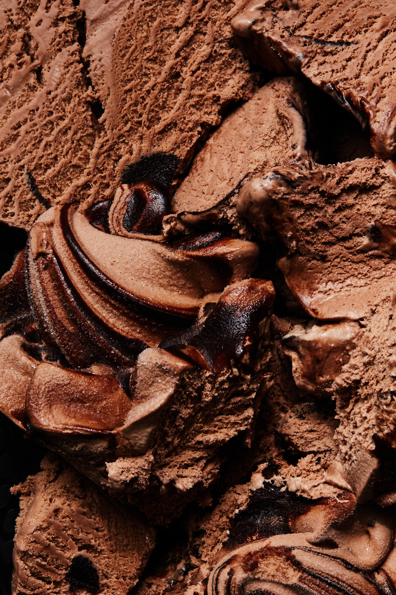 Close-up of rich chocolate ice cream with swirls of dark chocolate, highlighting its creamy texture and decadent appearance, great for food blogs.