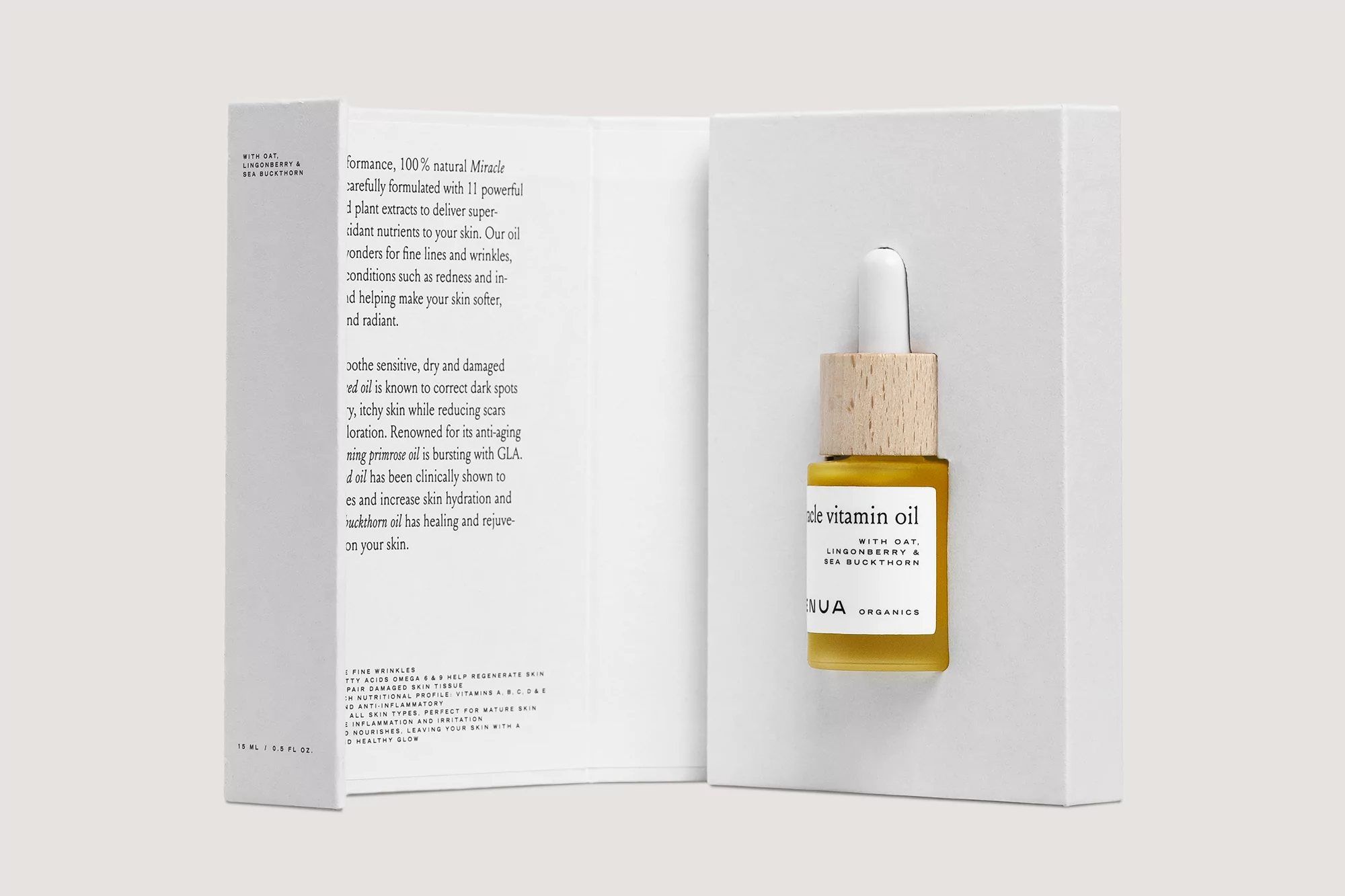 Close-up of Aqua Organics vitamin oil bottle in packaging. Small glass bottle with wooden cap, label details ingredients and branding.