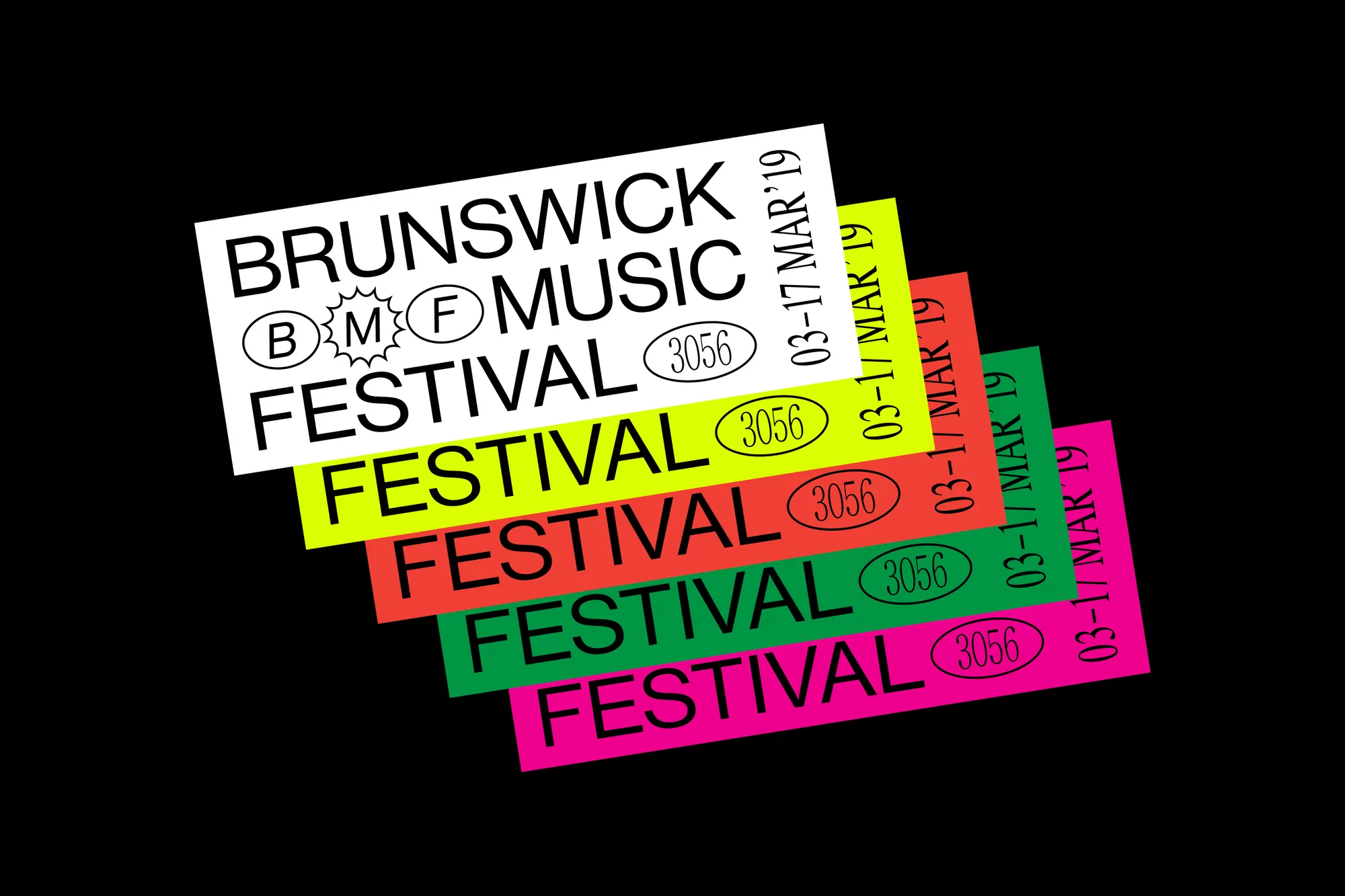Stacked promotional paper flyers with text 'Brunswick Music Festival,' featuring a black background, bold colors, and flat lay composition.