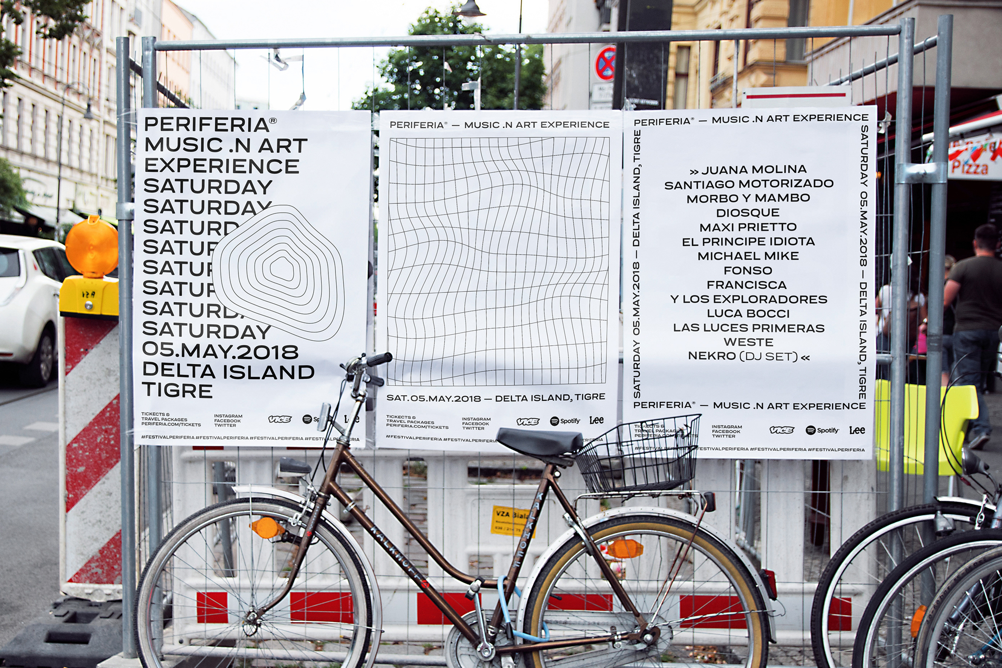 Bicycle parked in front of event posters advertising Periferia music and art experience in Delta Island, Tigre, featuring various artists and dates.
