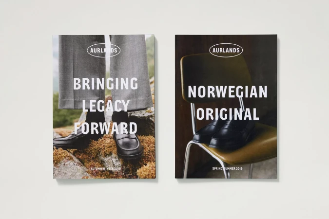 Two AURLANDS magazine covers feature black leather loafers. One shows shoes on moss, the other on a vintage yellow chair.