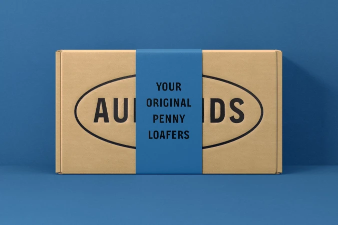 Eye-level studio shot of a cardboard box with dark text wrapped with blue paper displaying product-related information and branding.