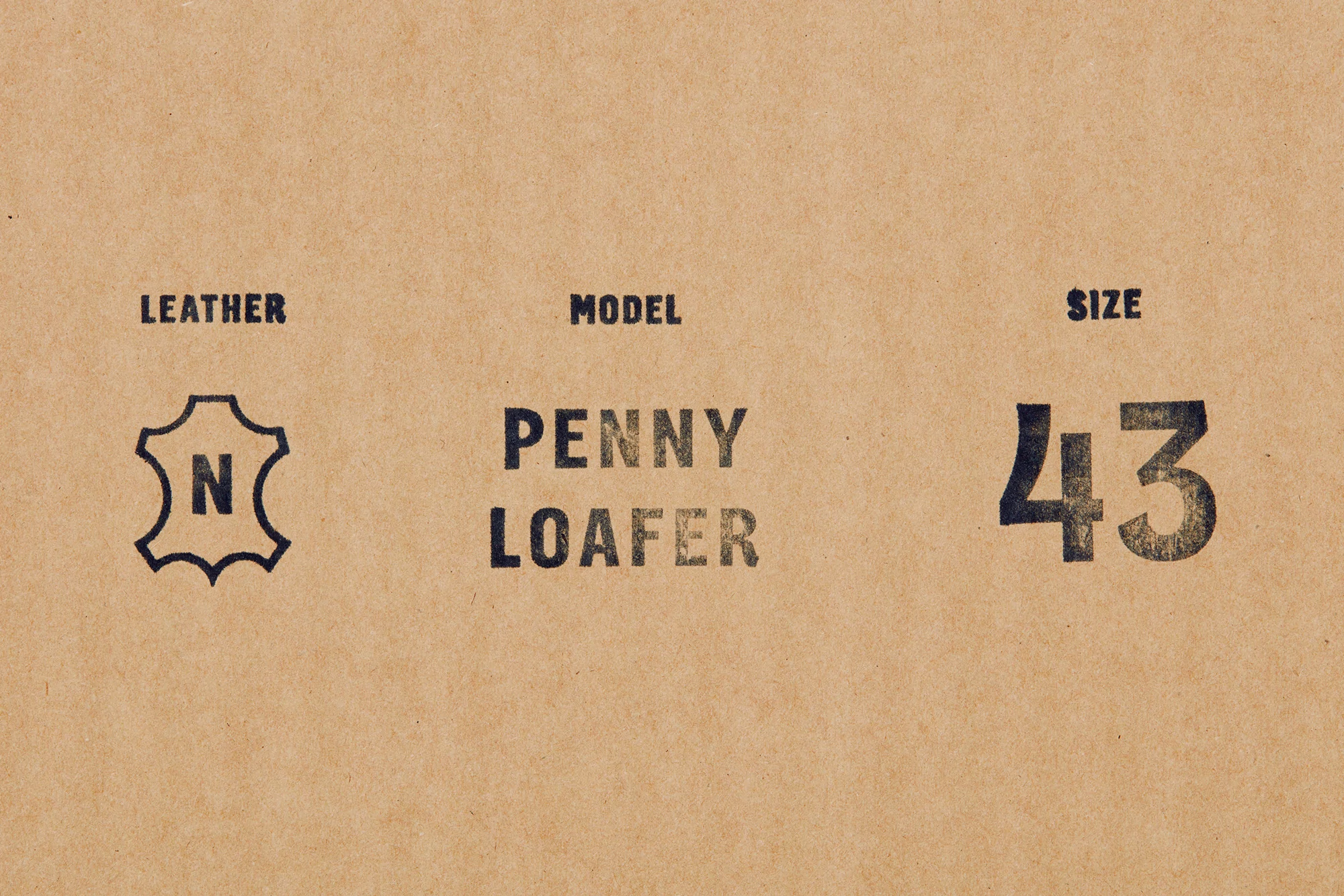 Close-up on a beige background showcasing the words 'Leather,' 'Model Penny Loafer,' 'Size,' and '43' along with a leather icon.