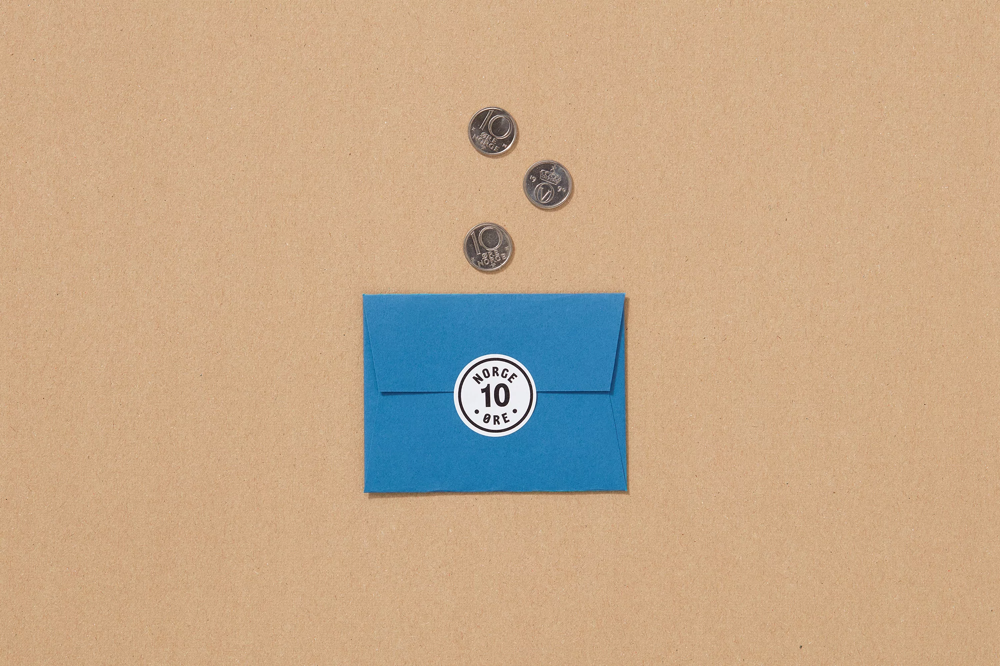 Overhead shot of a blue envelope with a white seal and three coins on a beige surface. Simple financial still life with copy space.