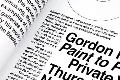 Close-up photograph of printed book pages displaying bold sans-serif typography and body text on white paper.