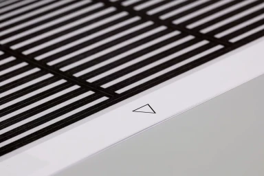 Close-up of graphic design print with black grid pattern and white border featuring a triangle symbol