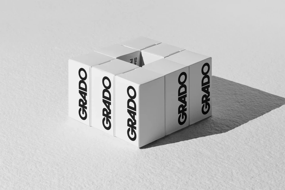 Grado brand cube, created from individual white cubes, in a studio setting with shadows, promoting Grado headphones and audio equipment.